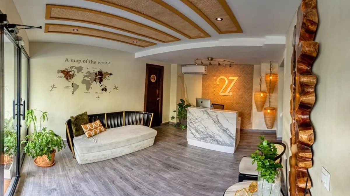 The front desk at Studio 27, with the 27 logo and a white armchair